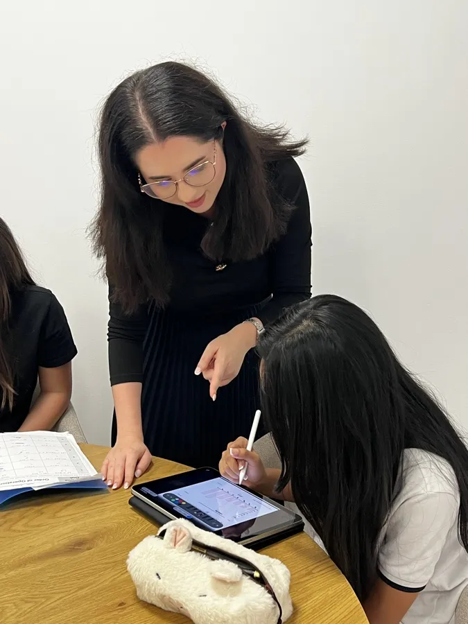 Ms Patricia pointing something out to Kinan as she works on her tablet
